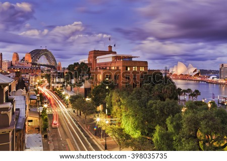 Aerial elevated view of The Rocks historic district in Sydney CBD as Sunset when bright lights illuminate city streets and landmarks.