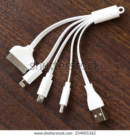 Universal Multiple USB Charging Cables on Wooden Background