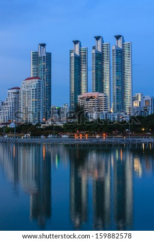 Commercial buildings with shadows on the water in the evening of Bangkok in Thailand.