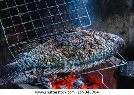 Grilled tilapia on the grill with charcoal fire.