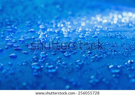 Rain Water droplets on blue fiber waterproof fabric