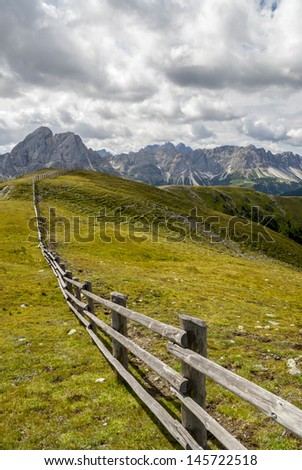 A long fence in the mountain meadows that seems to come on the horizon
