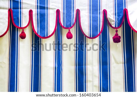 Detail of a blue and white striped tent with red bows