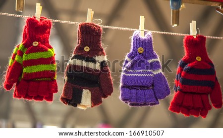 Colorful gloves hanging by a thread