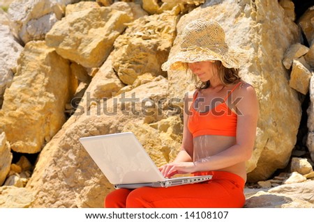 girl using laptop by the sea