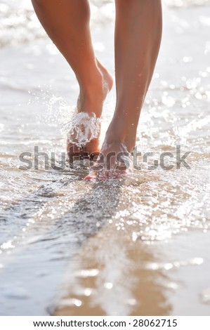nice woman legs walking on the beach