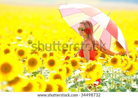 young woman with umbrella on field in summer