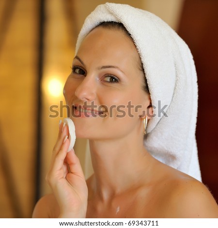 happy young woman cleansing her face