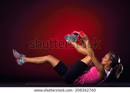 young woman exercising with elastic fitness band in the gym