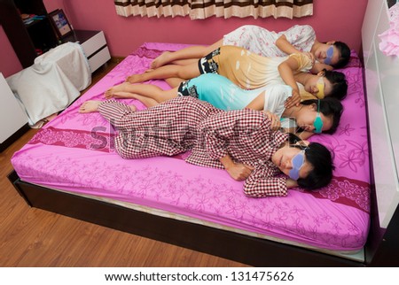 Asian Thai girls and boy sleep on one\'s side with eyes gel mask  on bed on World Sleeping Day.