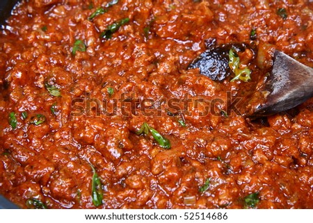 Spaghetti bolognese sauce with basil on a pan with a ladle