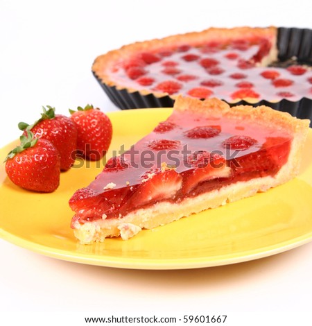 Piece of Strawberry Tart on a yellow plate decorated with strawberries with a tart in a tart pan in the background