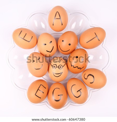 Eggs with an inscription EAT EGGS and some with smiling faces on a plate