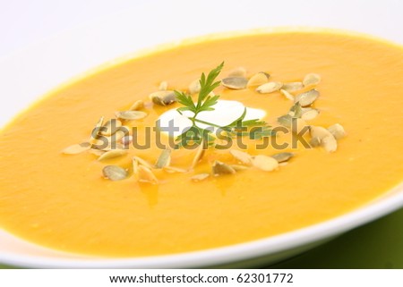 Pumpkin Soup decorated with cream, pumpkin seeds and parsley