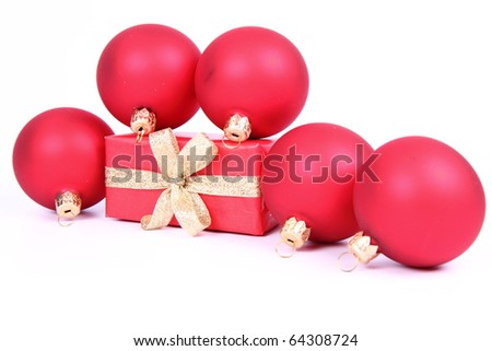 Red matte christmas balls and a gift in red wrapping on white background, with space for your text
