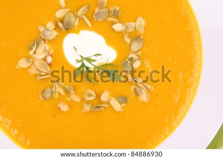 Pumpkin Soup decorated with cream, pumpkin seeds and parsley