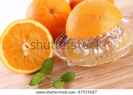 Orange juice being squeezed from fresh fruits with a juicer