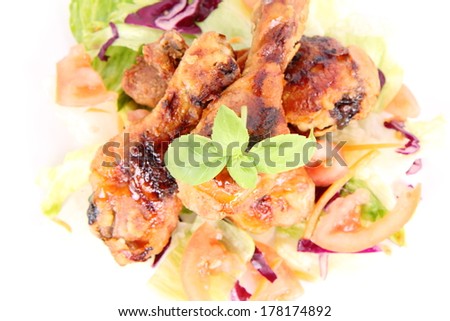 Fried chicken legs with side salad decorated with basil