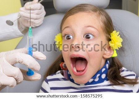 Little girl in the dentist office. Fear of anesthesia needle. Focus on anesthesia needle