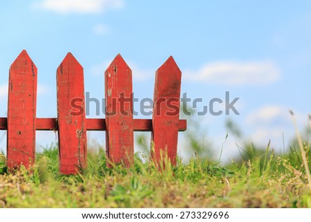 red old fence against blue sky