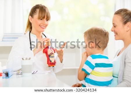 Young mom and her son at the doctors learning about vital organs