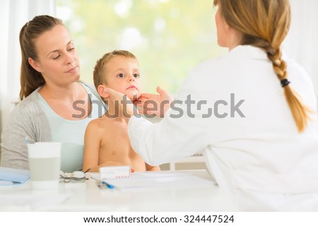 Doctor examining small boys glands at the doctors office