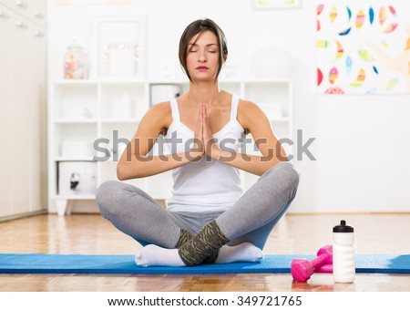 Young woman meditating and practicing yoga positions on a floor mat