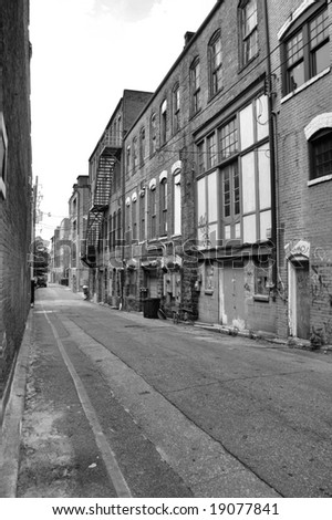 A view of a back alley in a southern town. Shown in black and white
