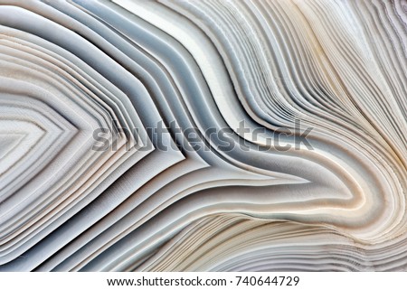 Amazing Banded Agate Crystal cross section as a background. Natural light translucent agate crystal surface, Gray abstract expressive structure slice mineral stone macro closeup