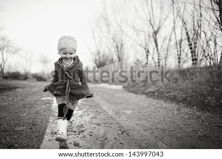 Little girl walking in through puddles