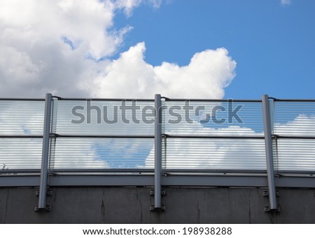 Metal and glass railing with blue sky horizontal