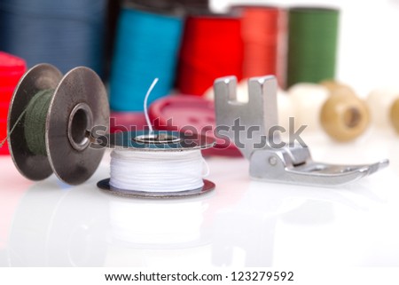 Metal spool of thread and coloured bobbins of thread