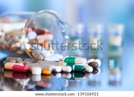 Colorful tablets with capsules and pills on blue background