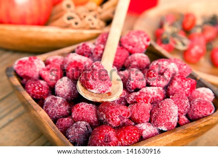 frozen raspberries in the wooden bowl