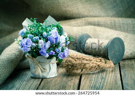 blue Campanula terry flowers in paper packaging, on wooden background