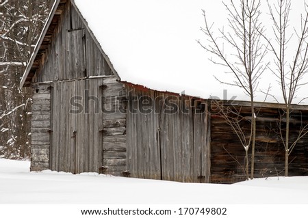 Winter snows pile up on an old weathered barn at an abandon cherry orchard in Door County, Wisconsin.