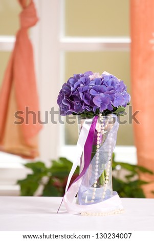 Beautiful lavender flowers in a bouquet next to a orange curtain