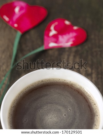 two hearts on string, coffee cup on old wooden boards