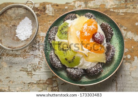 fruit tart with sugar powder in green plate on old table