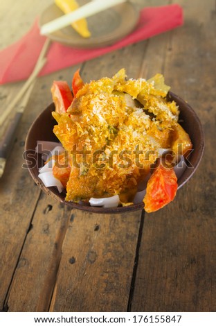 Asian dish with rice noodles and paprika on old wood