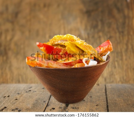 asian cuisine, rice noodles with red vegetables and  Thai coconut curry sause on wood background