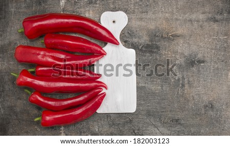 Long red fresh pepper,paprika on white cutting board,  old gray wooden background ,copy space