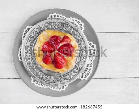 Strawberry cake on silver platter and lacy napkin, copy space