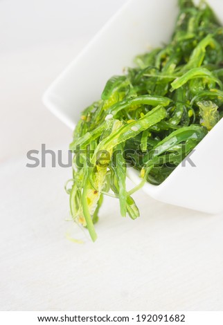algae salad in bowl on white wooden table