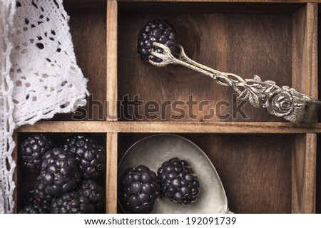 Blackberries, vintage kitchen tongs white napkin in old wooden box