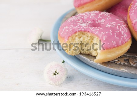 pink donut  bite off on blue plate