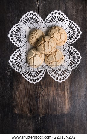 Cookies with cracks on  laced napkin  dark old desk , top view background with copy space