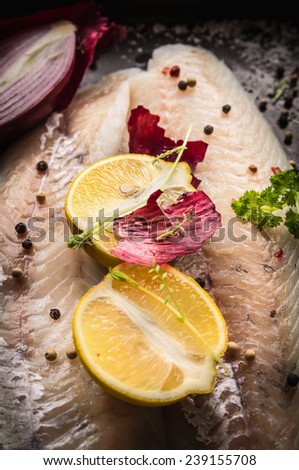 Lemon half with herbs and spices on raw Zander Fish fillet