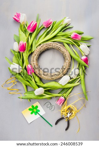Spring tulips flowers wreath making on gray background , top view