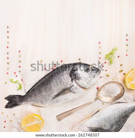 Raw dorado fish with lemon , spices and salt in spoon on white wooden background , food frame top view